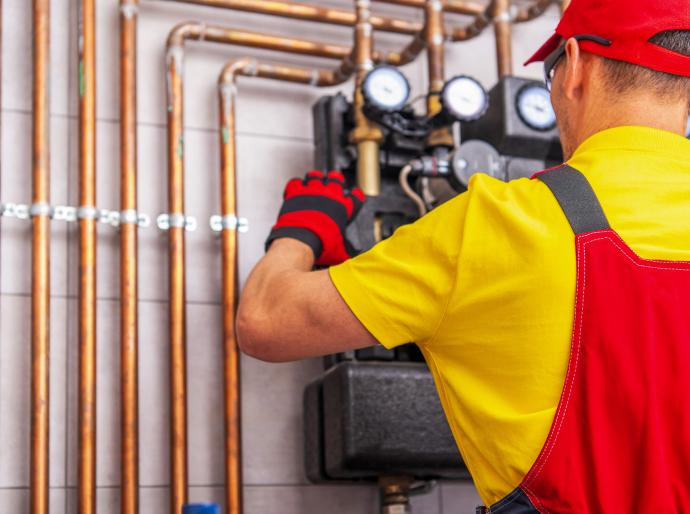 A gasfitter performing maintenance on a piping system