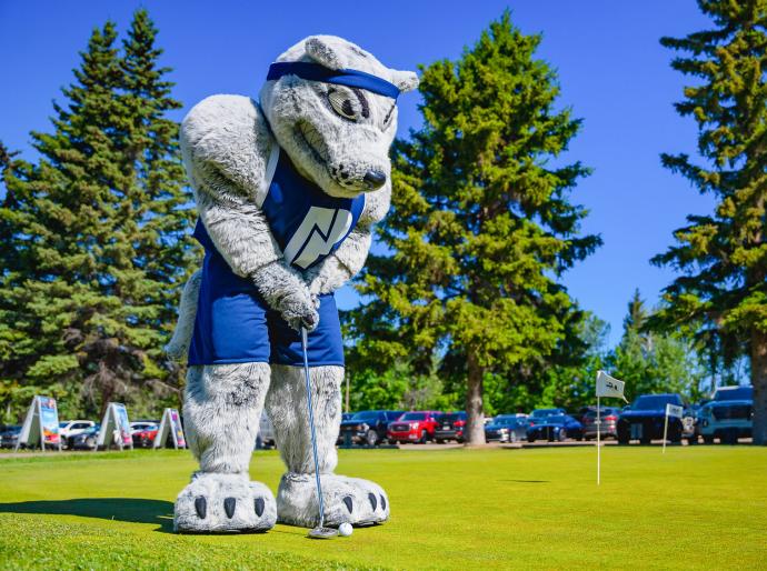 Farley the mascot sinking a putt at the NWP golf classic