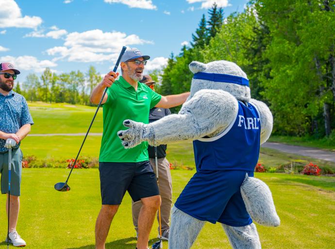 Farley the mascot shares an embrace with a happy golfer at the NWP classic