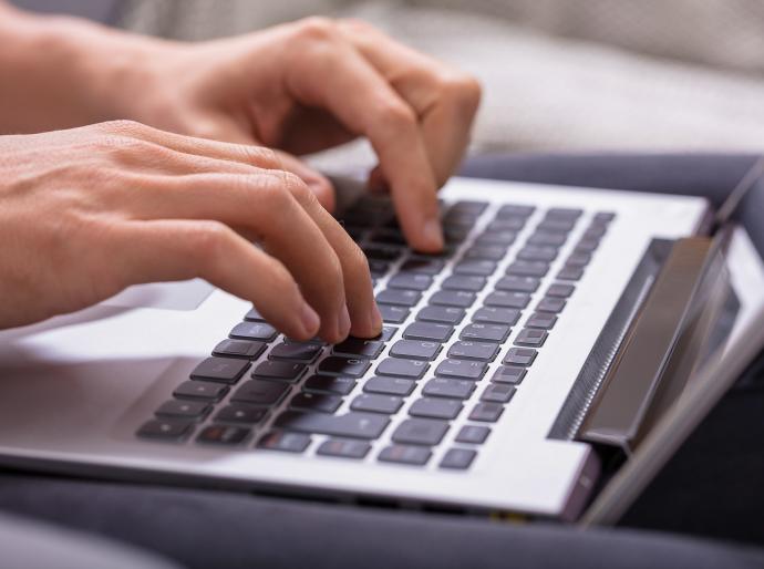 Close up of hands typing on a keyboard