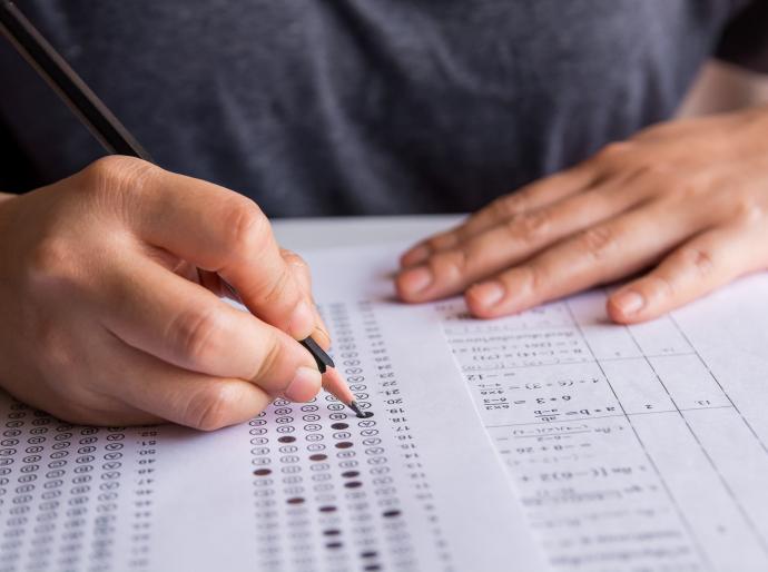 Close up of a student filling out and exam sheet with a pencil.