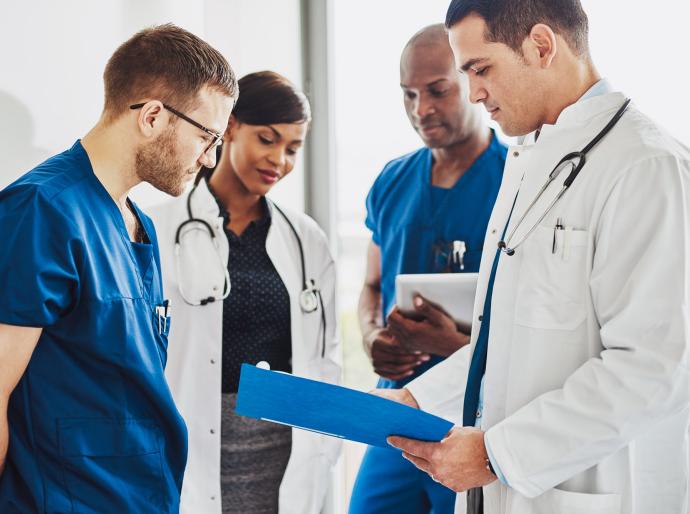 A group of young doctors reviewing a patients file