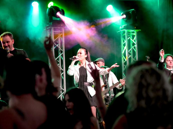 A lively image of the lead singer on stage the the 2024 presidents ball