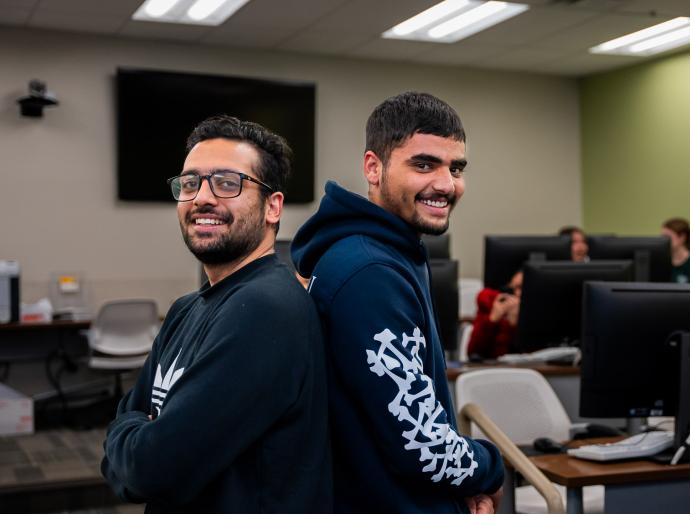 Happy international students standing back to back smiling at the camera
