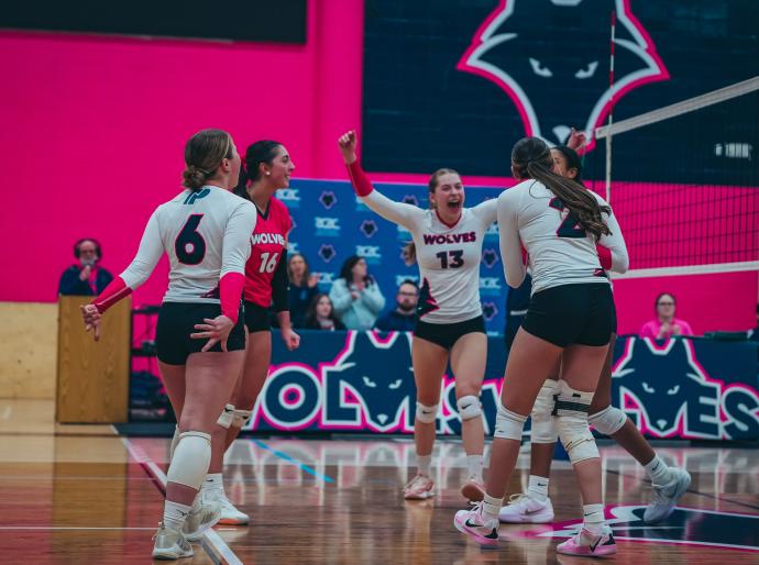 Womens wolves volleyball team celebrating on the court