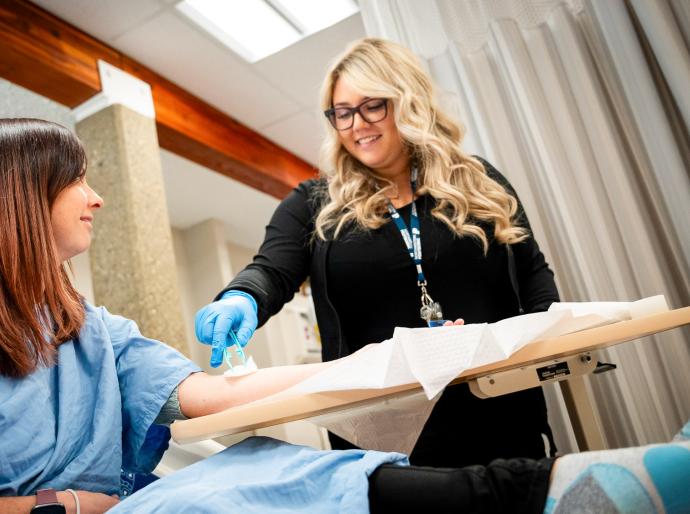 Health care aide student tending to a patient in the simulation lab