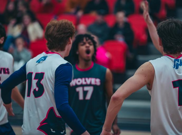 Mens wolves volleyball players celebrating in a huddle