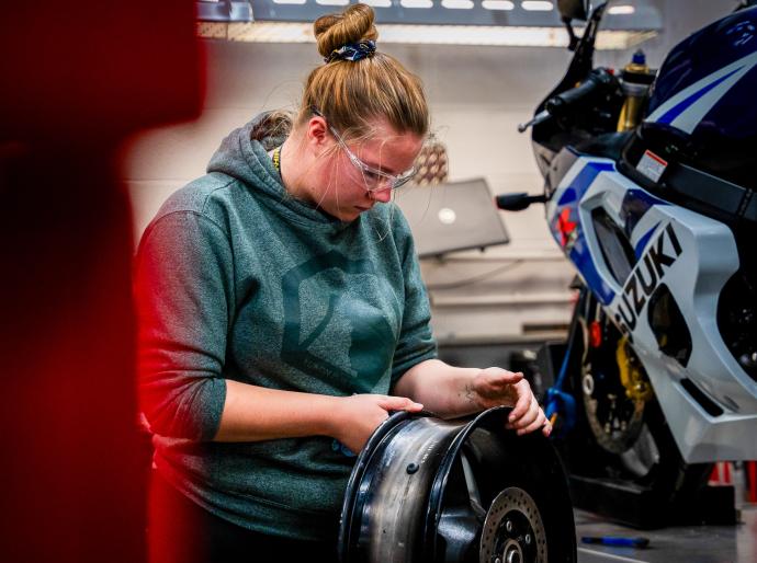 Motorcycle apprenticeship student working on a motorcycle in the workshop