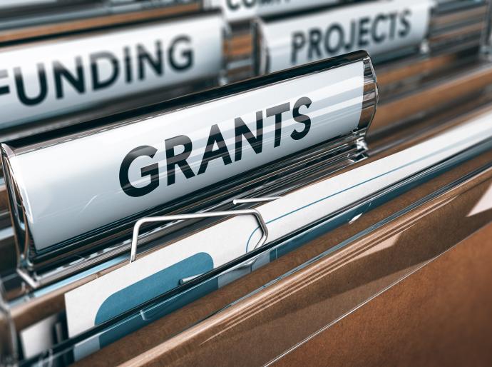 An open office drawer of folders with labels featuring titles that say grants, funding and projects.