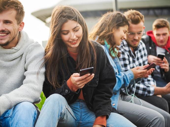 Students socialising while scrolling on their smart phones