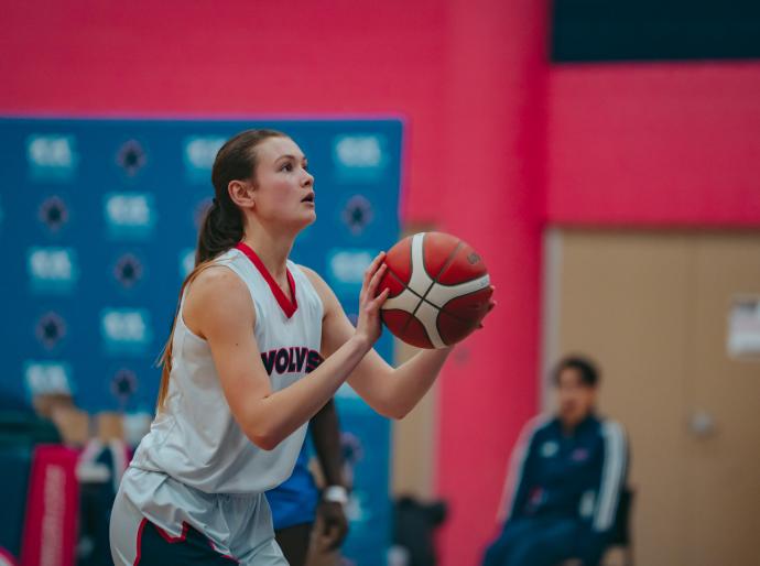 Woman wolves basketball player about to take the point shot