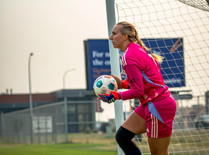 Wolves women's soccer goalie holding the ball after a save