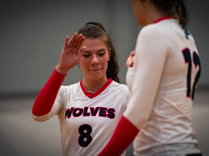 women's volleyball players giving each other high five