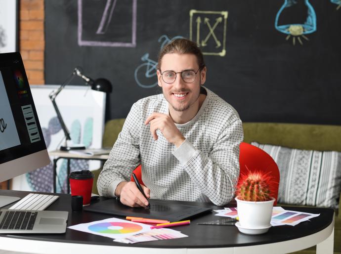 Happy graphic designer at his computer