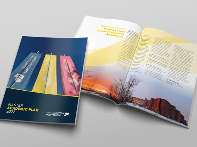 2 copies of the master academic plan on a table, one open and the other closed.