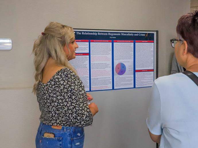 Student presenting a research presentation to interested attendees