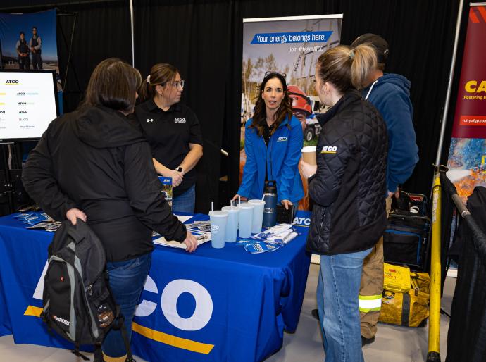 An exhibitor at the Career Fair chatting with visitors to their booth