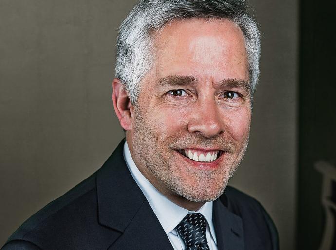 Headshot of a happy Roger Admiral sitting at his piano