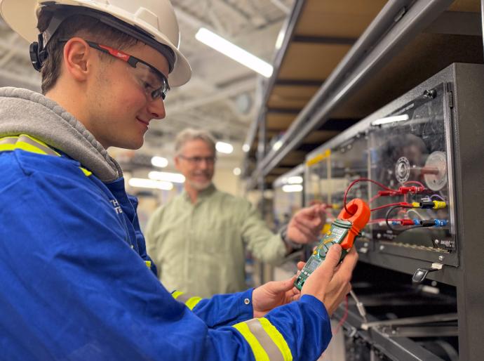 Electrical student using a device to measure electrical charge in the Ovintive Tool Hub
