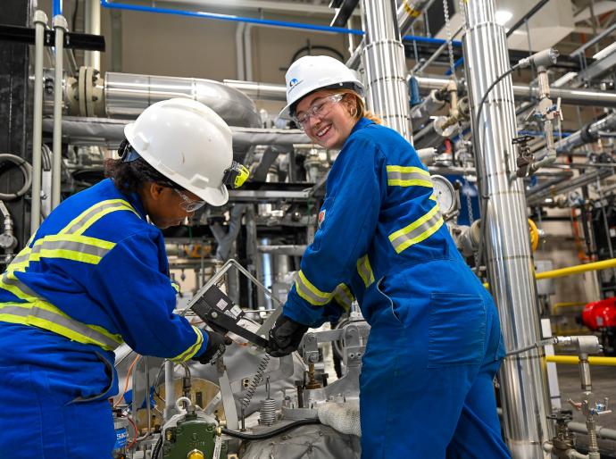 Two students working on power engineering equipment in an hands-on learning lab