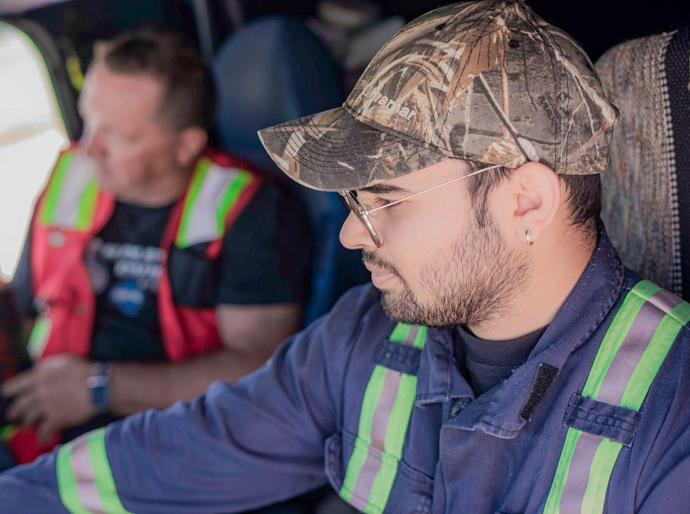 Truck driver in the cab of a semi with a driving instructor