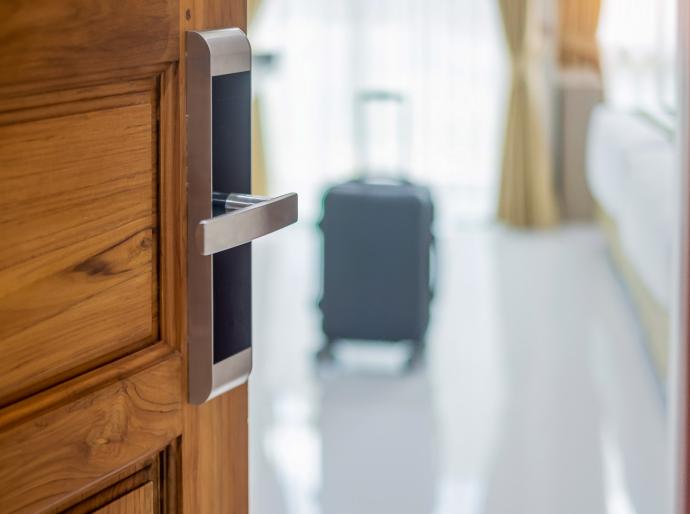 Hotel room door with a suitcase in the room