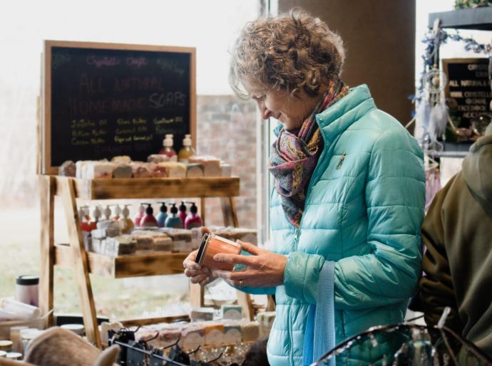 A customer perusing product at a vendor's stall at a craft market