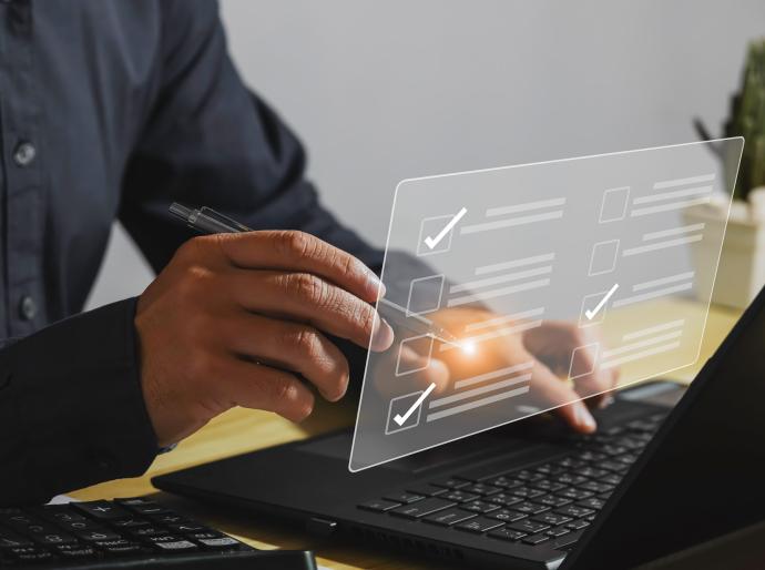 hands at a laptop selecting a checkbox on an online assessment questionnaire