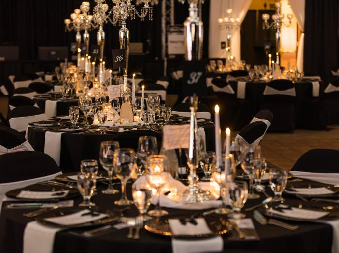 An elegantly decorated table at the President's Ball featuring a glittering centrepiece, sparkling tablewear, and beautifully folded napkins