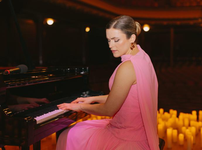 Pianist Michelle Lynne sitting at the piano with candles in the background