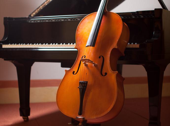 Cello leaning against a grand piano