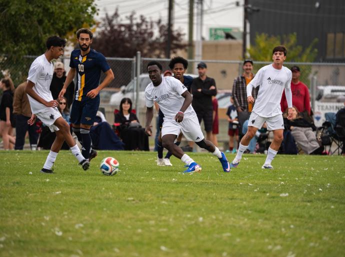 Wolves mens soccer players battling it out on the pitch in a match against Concordia Thunder