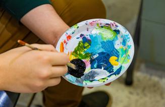 Close up of paintbrush mixing paint