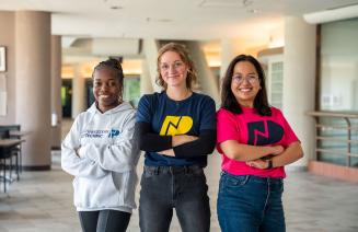 three students posing on the DJC concourse