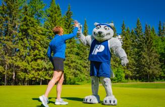 NWP mascot Farley high fiving with a golfer at the NWP classic golf tournament