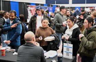 Several attendees talking to a vendor at the 2024 NWP Career Fair