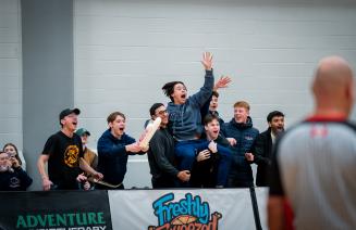 Excited fans cheer loudly for the Wolves basketball team, creating an energetic atmosphere in the Wolfden.