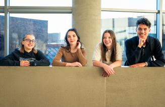 Four happy students smiling and looking at the camera