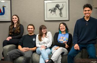 A cheerful group of Indigenous students sitting on a couch in the Friendship Centre
