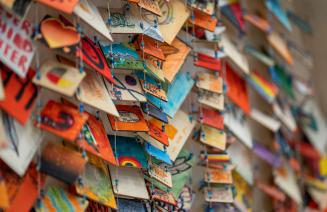 Closeup of little hand made cards strung together to form an art piece in honour of Orange Shirt Day