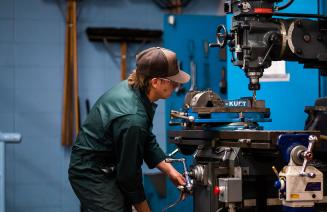 A tradesperson diligently operating a large piece of industrial equipment in a well equipped workshop.