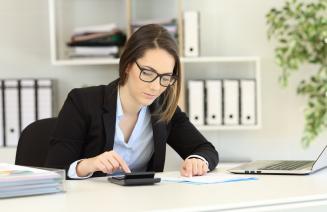 Smartly dressed professional woman focused on work in her office.