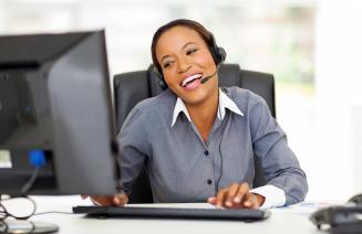 Professionally dressed woman with a headset engaging in customer service with a smile