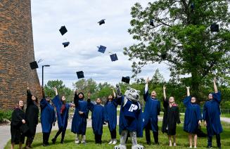 A group of graduates throwing their mortarboards into the air