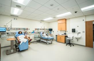 The simulation lab featuring two beds with dummies, one with a pregnant woman and the other a young child