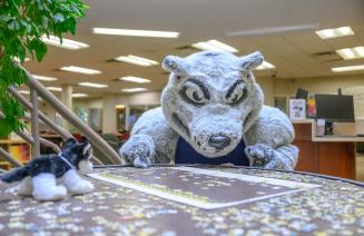 Farley the mascot putting puzzle pieces together