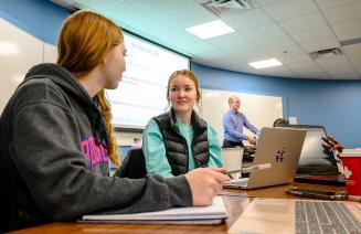 Two students working on a group project in a marketing class