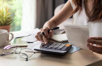 Close up of a student using a calculator to pay bills