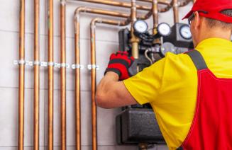 A gasfitter performing maintenance on a piping system