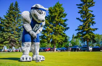 Farley the mascot sinking a putt at the NWP golf classic